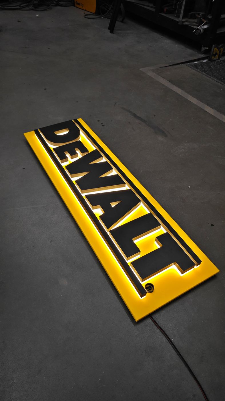 Podsvícené logo DeWalt nad výstavkou nářadí
