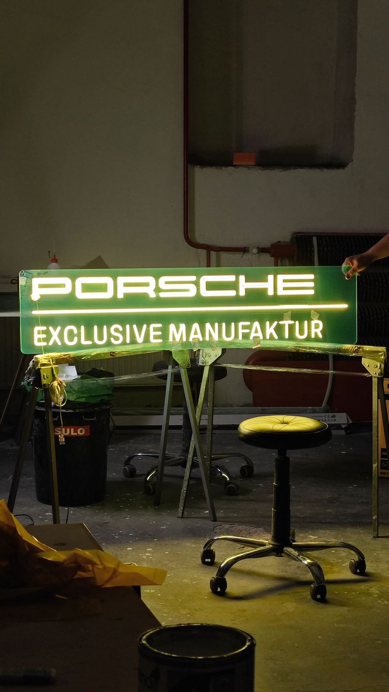 Zelený LED neon s nápisem Porsche Exclusive Manufaktur v dílně